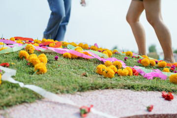 Gold yellow flower decorated on Chinese graveyard with colorful flower and ribbon on green grass field on Qingming festival or Tomb sweeping day to respect to ancestor. Chinese memorial name concept. - 742763210