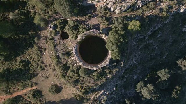 Aerial view looking at a nevera (snow pit) these snow pits were used in antiquity to preserve the fallen snow, Cava Don Miguel, Mariola mountain, Alicante, Spain - stock video