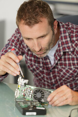 man is repairing broken pc with a screw driver