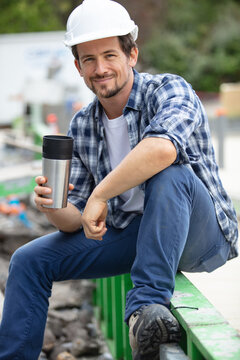 workman sitting relaxing drinking coffee