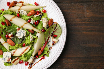 Delicious pear salad with sauce on wooden table, top view. Space for text