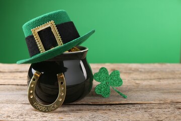 St. Patrick's day. Pot of gold with leprechaun hat, horseshoe and decorative clover leaf on wooden...