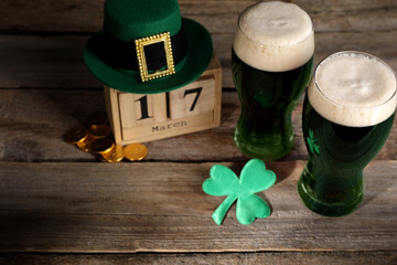 St. Patrick's day celebrating on March 17. Green beer, block calendar, leprechaun hat, gold coins...