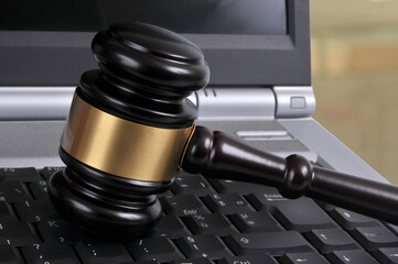 Concept de justice avec un marteau de juge sur un clavier d'ordinateur portable en gros plan