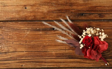 Fototapeta premium Beautiful boutonniere on wooden background, top view. Space for text