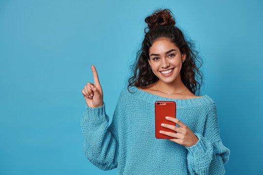 Young happy latin woman holding mobile pointing aside isolated on blue background. Smiling female model holding cellphone using cell presenting advertising new trendy shopping sale in, Generative AI