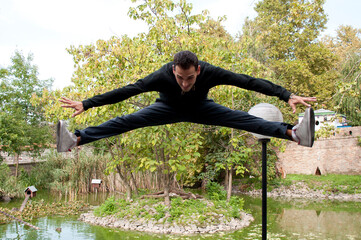 A young acrobatic dancer dances in nature