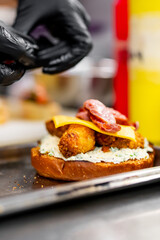 chef hand cooking cheeseburger with vegetables and meat on restaurant kitchen