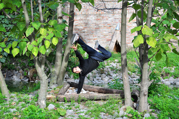 A young acrobatic dancer dances in nature