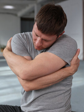 Man hugging herself, self-love, self-acceptance concept. somatic nervous system balancing exercises