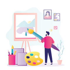 Creative man paints picture at an easel. Young guy paints abstract picture with watercolors and oils. Giant brush in hands of the male artist.