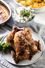 A whole roasted chicken on the table together with jasmine rice and baked potatoes - 742798287