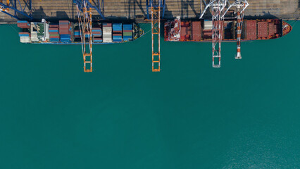 Aerial top view over international containers cargo ship at industrial import-export port prepare to load containers with big container loader ship vessel. global transportation and logistic business.