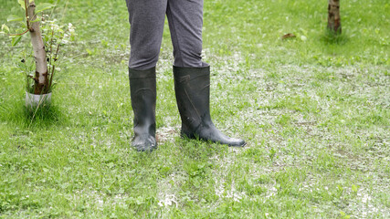 The person stands in the garden in the water, legs in wellies. The garden is flooded. Consequences...