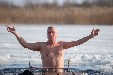 An elderly man bathes in an ice hole on the Orthodox feast of the Epiphany.  Take a dip in the icy water.
