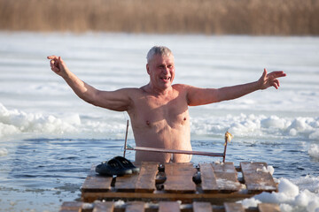 An elderly man bathes in an ice hole on the Orthodox feast of the Epiphany.  Take a dip in the icy...