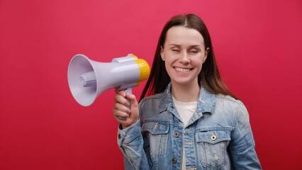 Portrait of surprised fun promoter young woman 25 old years wearing denim jacket scream in megaphone announces discounts sale Hurry up, posing isolated over plain red color background wall in studio