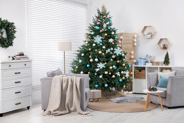 Christmas tree in room decorated for holiday. Festive interior design