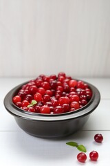 Fresh ripe cranberries on white wooden table, space for text