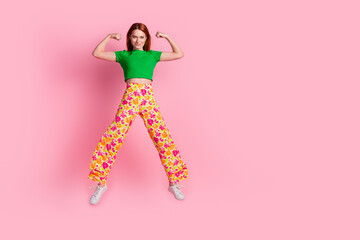 Full length photo of strong adorable woman dressed green t-shirt jump clenching fists demonstrate...