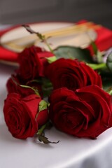 Beautiful red roses on white table indoors, closeup