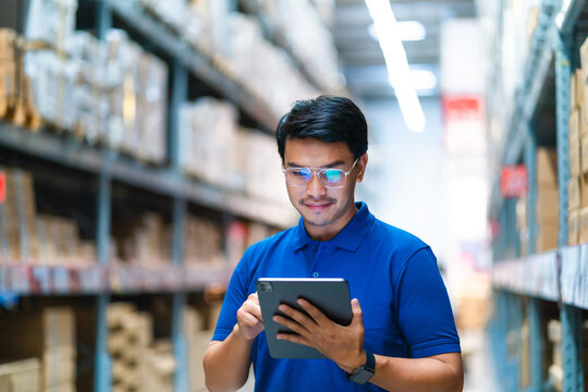 Logistics and export concepts Warehouse manager uses a tablet computer to monitor products in the warehouse. logistics system distribution center.