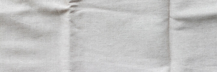 Soft light gray natural linen texture banner. Crumpled fabric background. Panoramic web header....