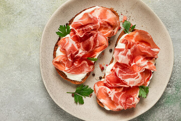 sandwich with cream cheese and prosciutto, on black grain bread, breakfast, homemade,