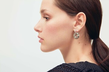 Close up portrait of a beautiful elegant woman with freckles with stylish jewelry on a white...