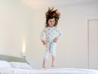 Fototapeta na wymiar girl jumping on the bed