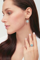 Close up portrait of a beautiful elegant woman with freckles with stylish jewelry on a white...