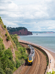 A passenger train travelling along the spectacular rail route towards Dawlish in Devon UK