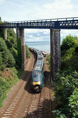 A passenger train service  approaching Teignmouth station in Devon UK with a missing nose cone