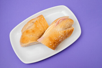 a spanish rosca de jamon serrano, ham sandwich, on a white plate