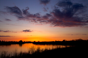 Obraz premium Dusk by the lake in a golden glow and colorful clouds