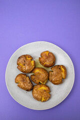 Tasty pieces of baked potatoes and salt and oil on plate