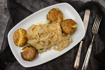 Traditional portuguese cousine, cod fish with potatoes and onions, covered with oil.