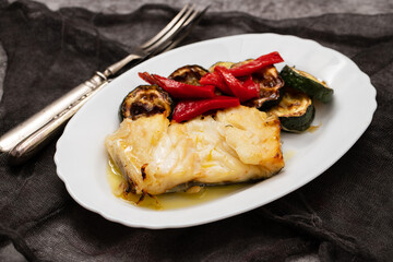 Fish dish - fried cod fish with grilled vegetables in plate