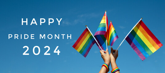 'HAPPY PRiDE MONTH 2024' on bluesky and rainbow flags raising background, concept for lgbtq+...