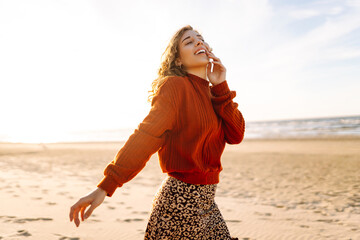 Portrait of the beautiful woman at the windy spring day relaxing on coast. Travel, weekend, relax and lifestyle concept. - obrazy, fototapety, plakaty