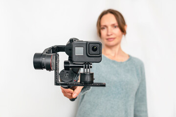 Naklejka premium Modern portable video-photo stabilizer. Blur background woman. Vlog and video blog concept.