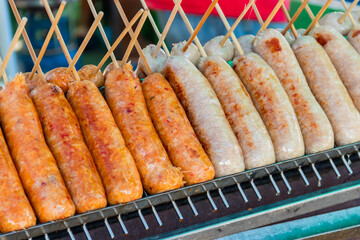 Thai Style Grilled Sausage (Sai Krok Isan) on stove. - obrazy, fototapety, plakaty