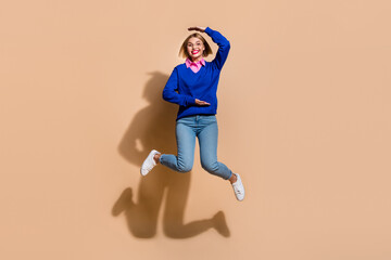 Fototapeta na wymiar Full body length size photo of funny young business lady measure her height when jumping trampoline isolated on beige color background