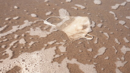photo of a mask washed up by the waves on the beach