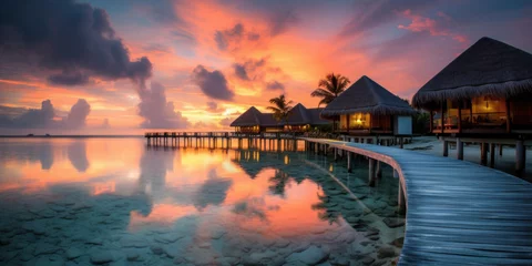 Fototapeten Maldives at a resort on the island at sunset. © Wararat