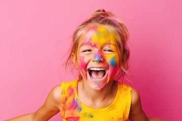 A cheerful young girl shows her hands covered with multicolored paint, her joy unmistakable against a pink background.