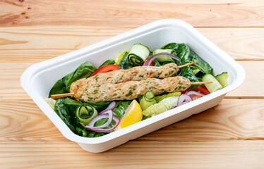 Chicken lula kebab with herbs and vegetables. Healthy food. Takeaway food. On a wooden background.