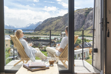 Couple relaxing on the balcony with a view of mountain
