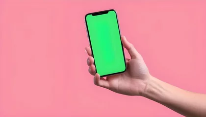 Fotobehang Human hand holding mobile smartphone with green screen in horizontal position isolated on pink background. clipping path © Moldovan