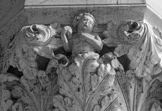 Venice, Italy, Sept. 17, 2023: A Doge’s Palace portico sculpture of a boy, or putto, amid ornate leaves, fruit in hand, shows the skill of the city’s medieval stone carvers.